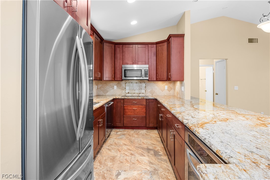 1813 Long Point Lane Sanibel, FL 33957 - Photo 3 of 38 a kitchen with granite countertop a refrigerator and a sink