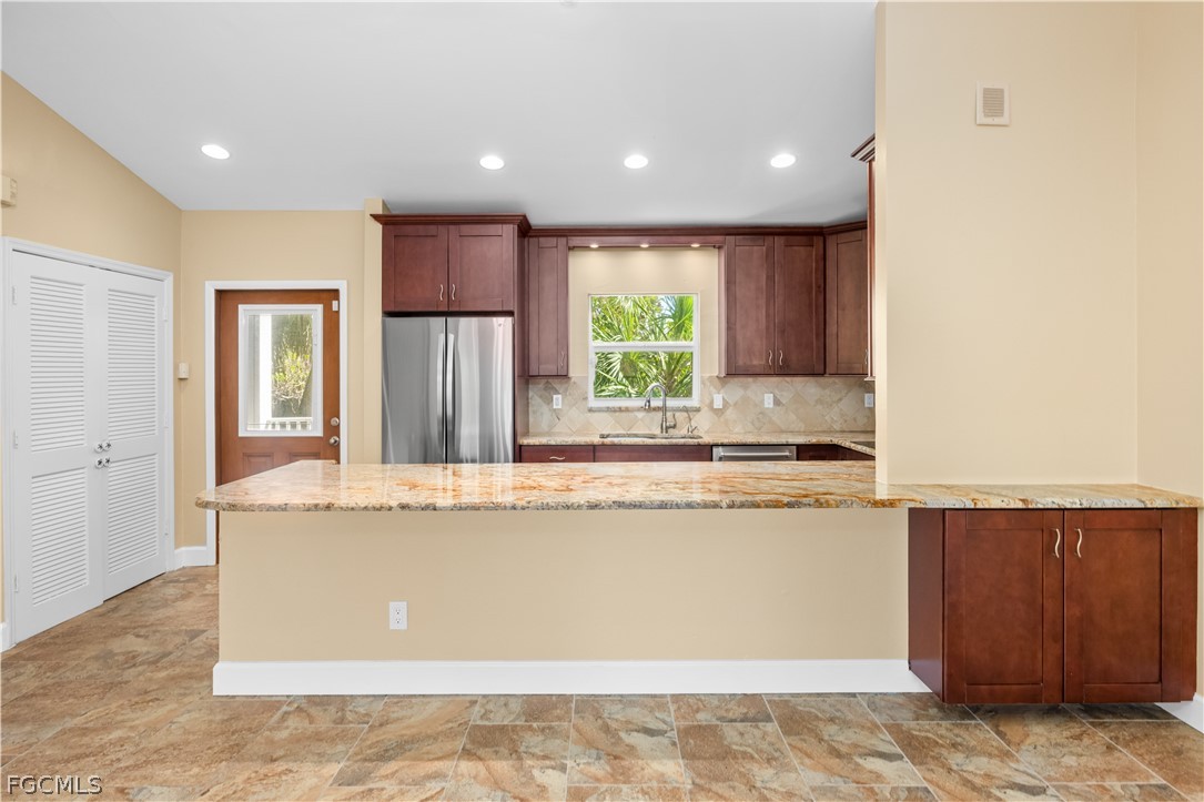 1813 Long Point Lane Sanibel, FL 33957 - Photo 6 of 38 a view of kitchen with stainless steel appliances granite countertop a refrigerator and a sink