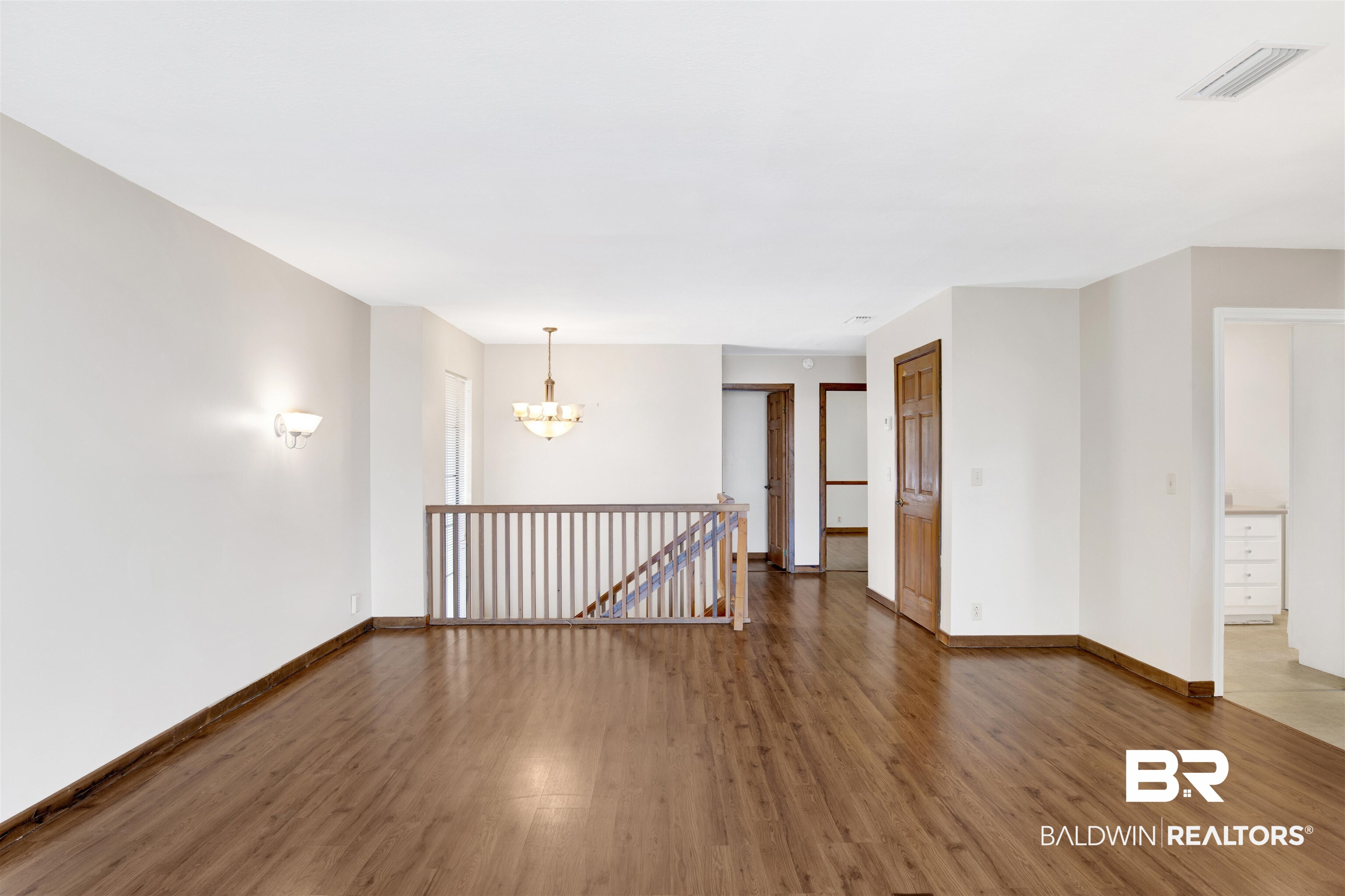 7411 Bay Road Mobile, AL 36605 - Photo 11 of 34 Unfurnished room featuring wood finished floors and a chandelier