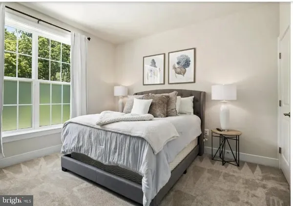 a large bed sitting in a bedroom next to a window