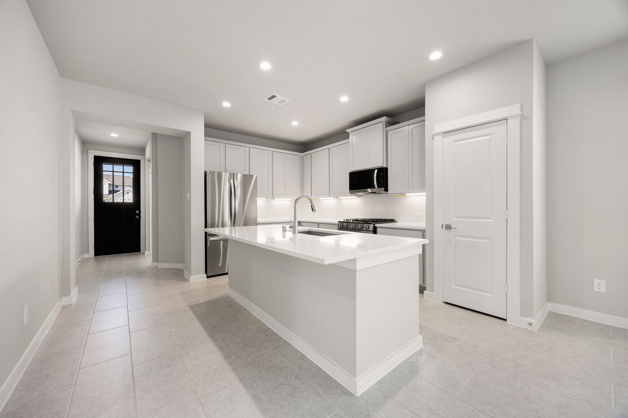 33007 Carolyns Perfection Loop Fulshear, TX 77441 - Photo 2 of 31 Kitchen with center island and breakfast bar, stainless appliances and open to the family room.