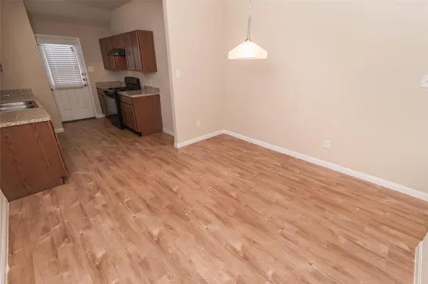 a view of a kitchen with fridge and wooden floor