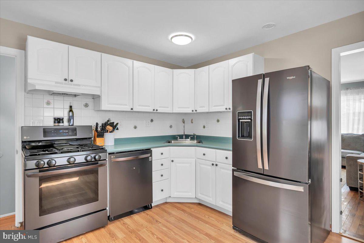 216 Evergreen Avenue Mantua, NJ 08051 - Photo 14 of 30 a kitchen with cabinets stainless steel appliances and wooden floor