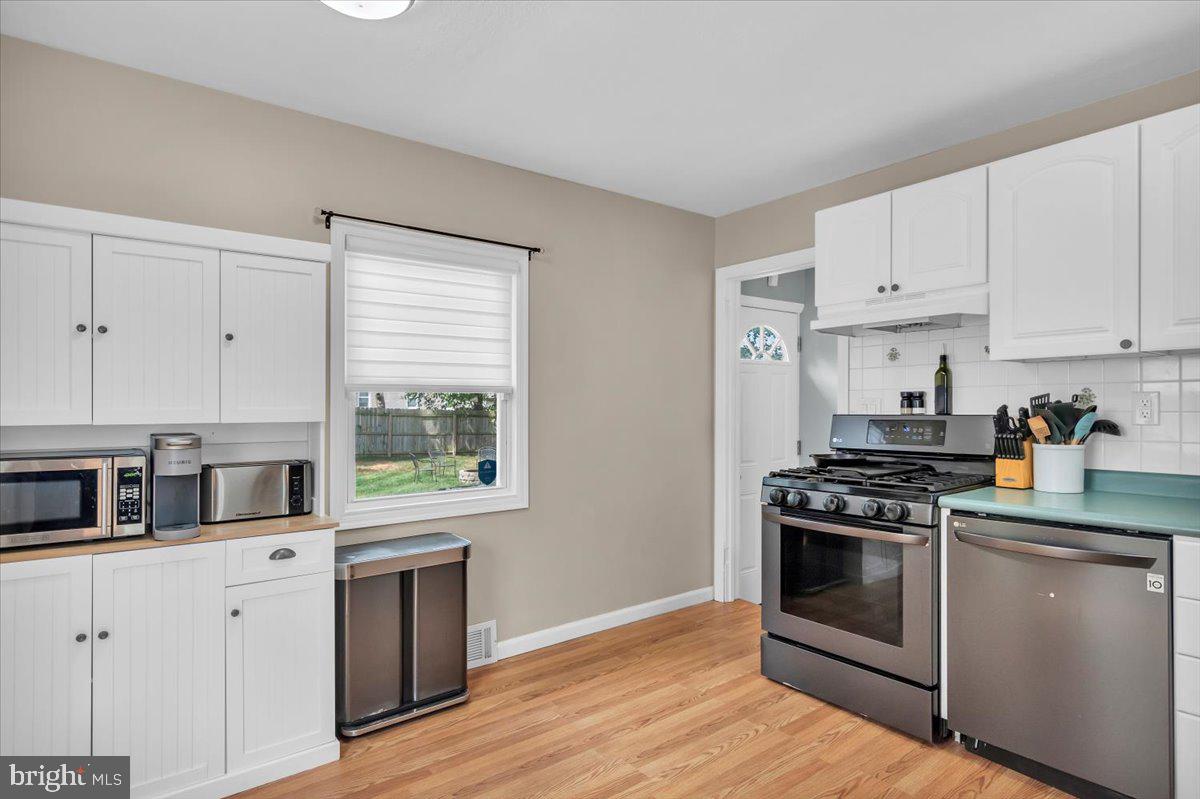 216 Evergreen Avenue Mantua, NJ 08051 - Photo 16 of 30 a kitchen with stainless steel appliances white cabinets granite counter tops and a wooden floors