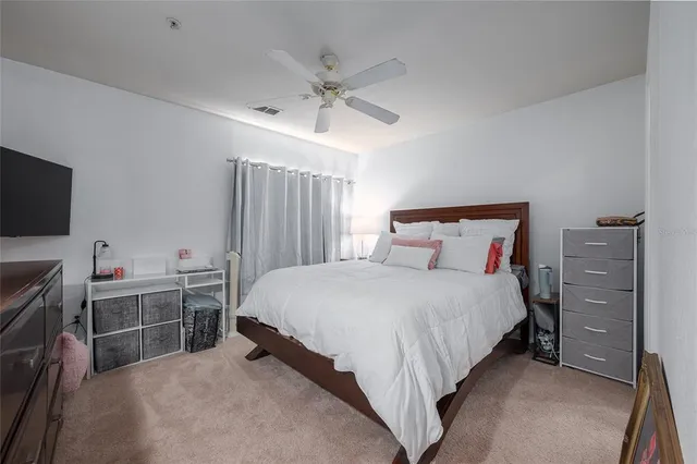 a bedroom with a bed and a flat tv screen on dresser