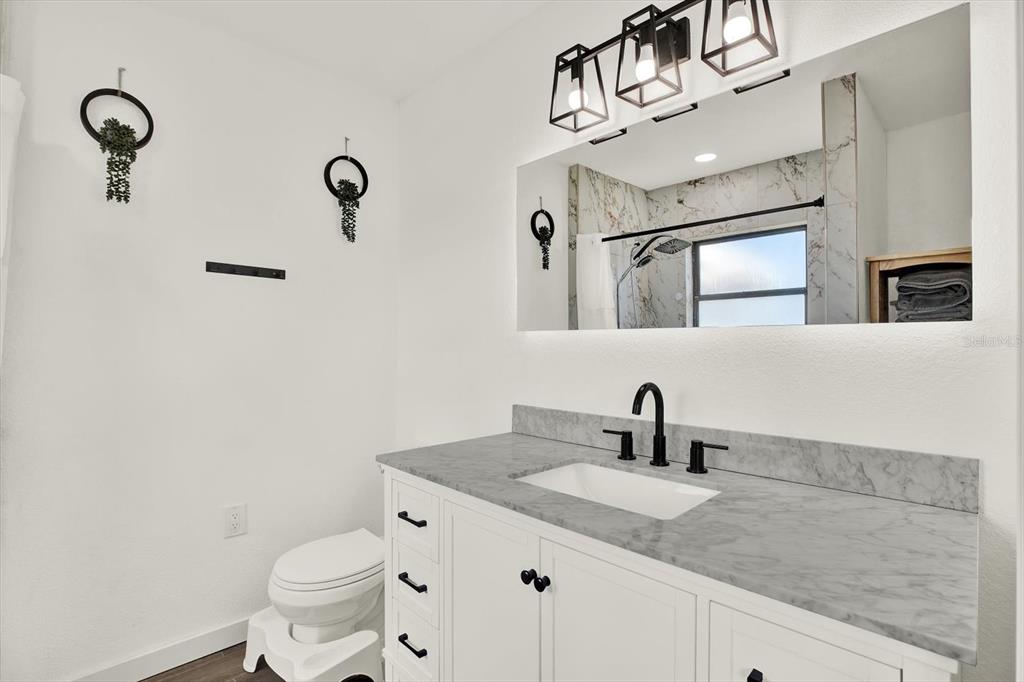 6060 39th Avenue North St. Petersburg, FL 33709 - Photo 15 of 29 a bathroom with a toilet sink double vanity and mirror