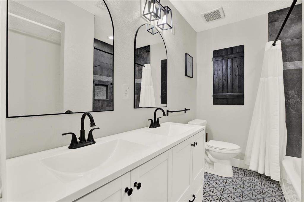 6060 39th Avenue North St. Petersburg, FL 33709 - Photo 17 of 29 a bathroom with a sink a toilet and a mirror