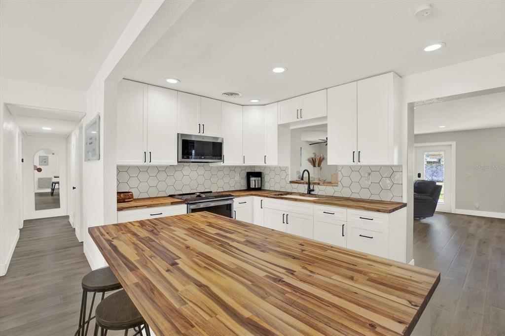 6060 39th Avenue North St. Petersburg, FL 33709 - Photo 7 of 29 a large kitchen with kitchen island a sink stainless steel appliances and white cabinets
