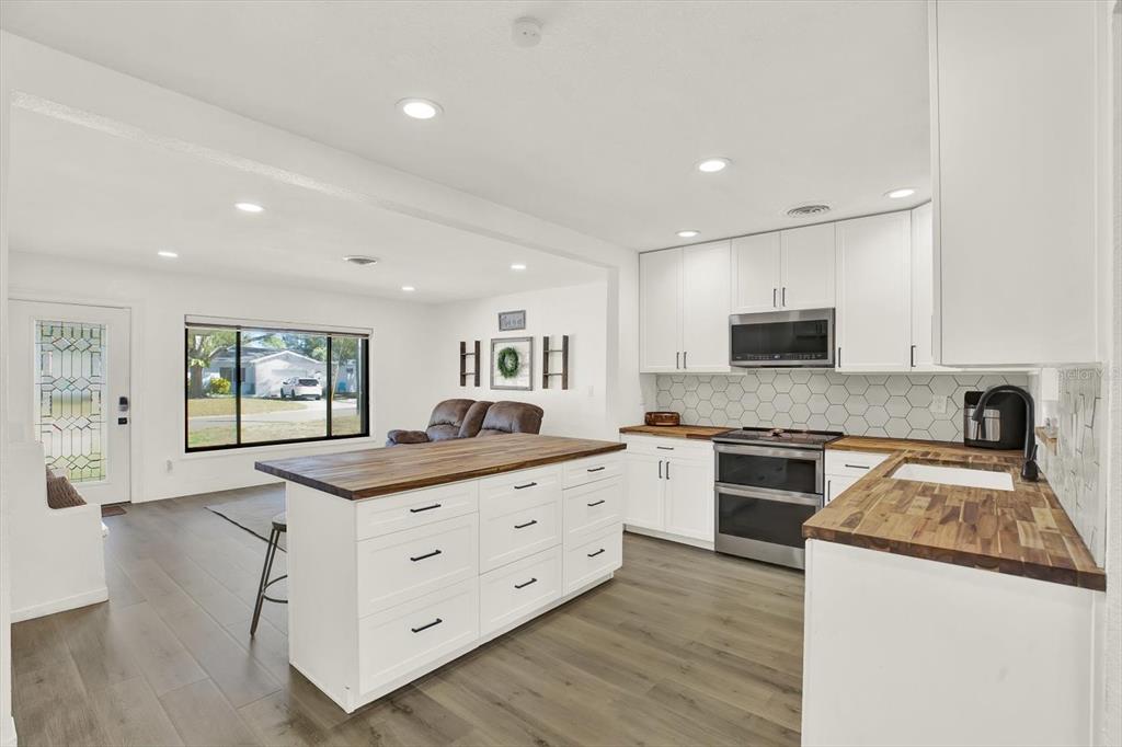 6060 39th Avenue North St. Petersburg, FL 33709 - Photo 9 of 29 a kitchen with granite countertop a sink and a stove top oven