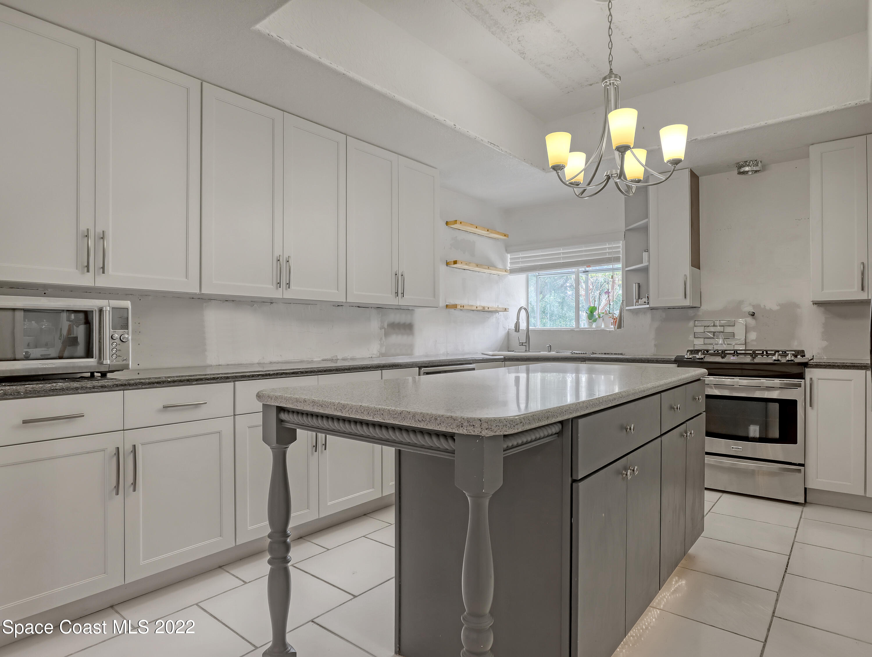 4304 Long Lake Road Melbourne, FL 32934 - Photo 13 of 40 a kitchen with granite countertop stainless steel appliances a stove a sink and a white cabinets