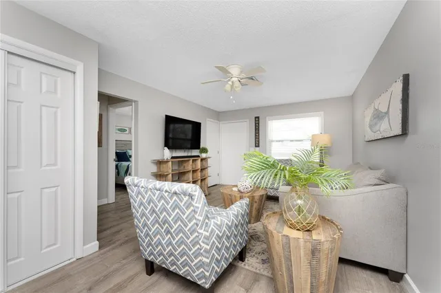 a living room with furniture a flat screen tv and a potted plant