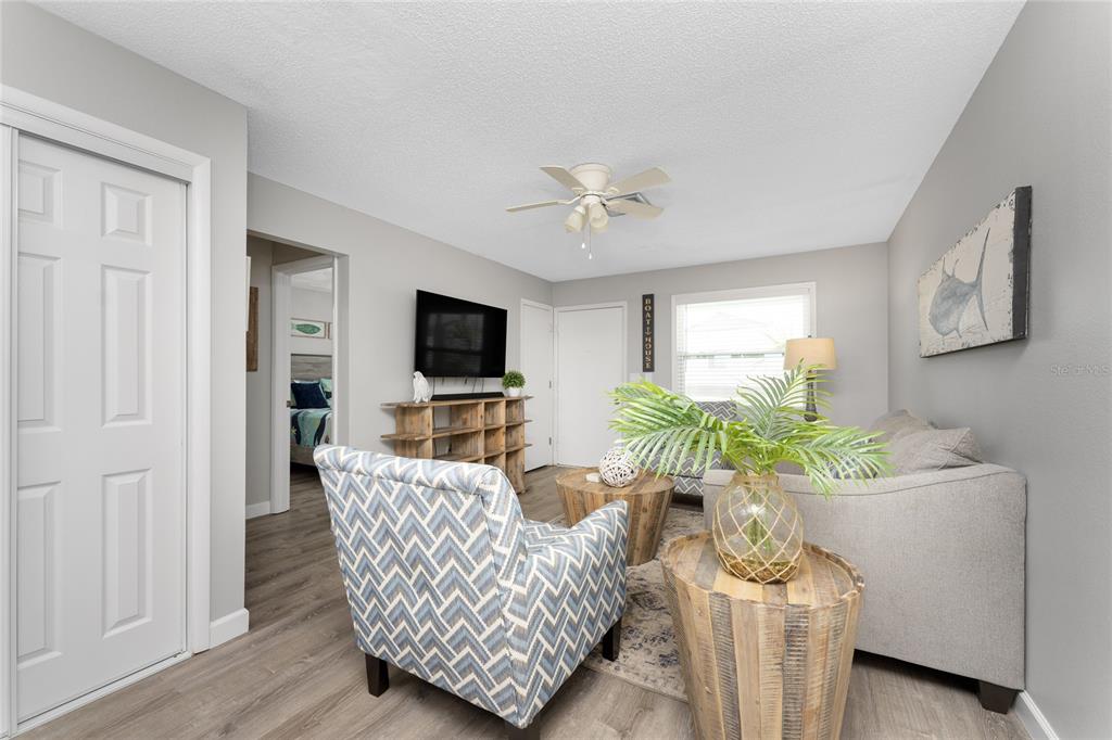 5041 North Beach Road, Unit 4A Englewood, FL 34223 - Photo 6 of 18 a living room with furniture a flat screen tv and a potted plant