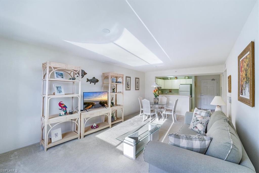 8288 Key Royal Lane, Unit 1424 Naples, FL 34119 - Photo 2 of 13 a living room with furniture and a flat screen tv