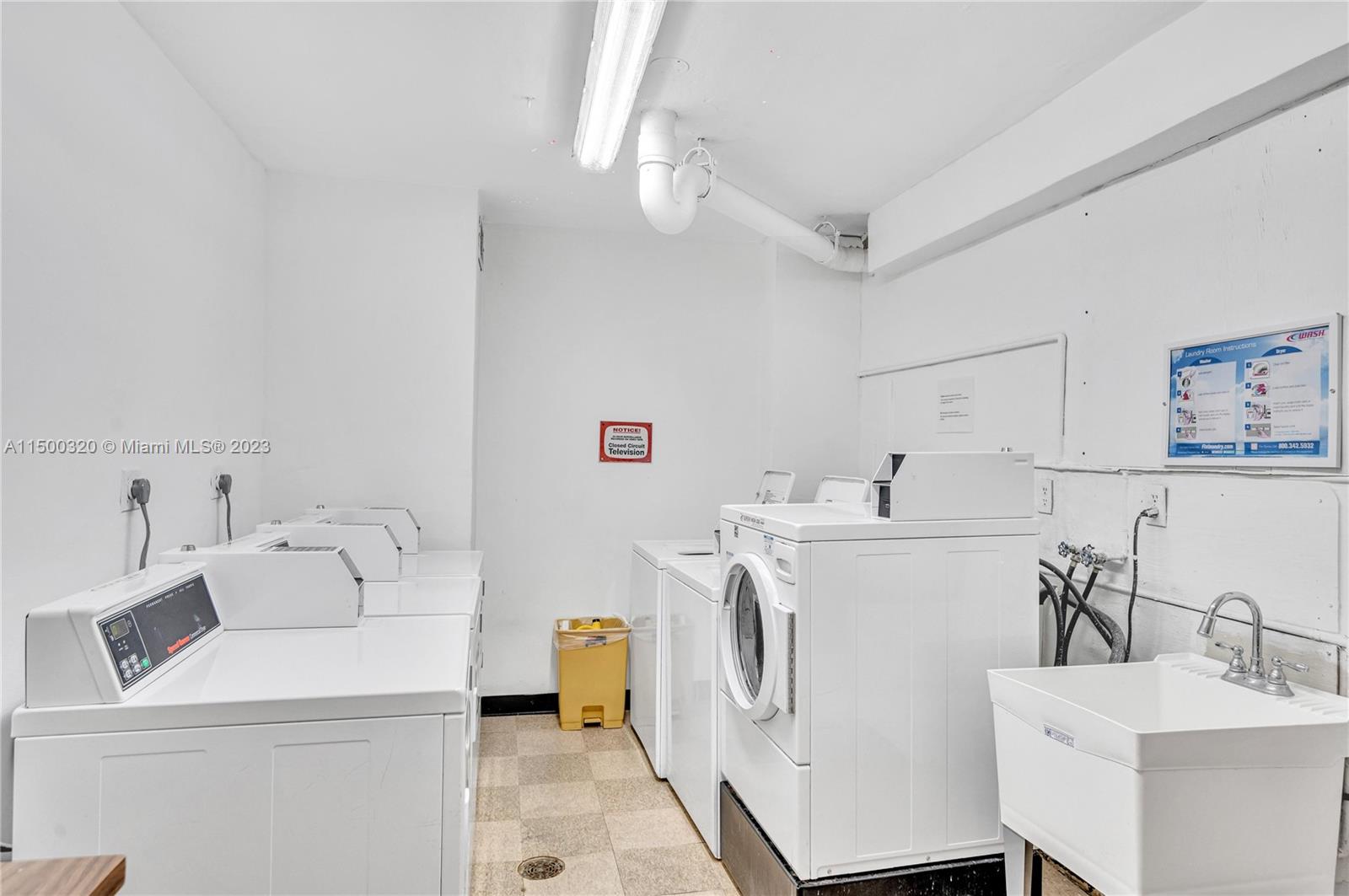 4101 Pine Tree Drive, Unit 707 Miami Beach, FL 33140 - Photo 16 of 21 a utility room with cabinets dryer and washer