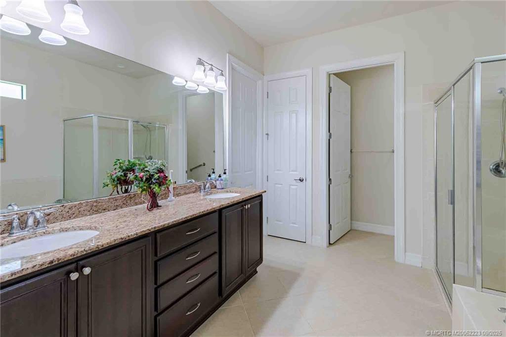 1092 Southwest Scrub Oak Avenue Palm City, FL 34990 - Photo 11 of 45 a bathroom with a double vanity sink and a mirror