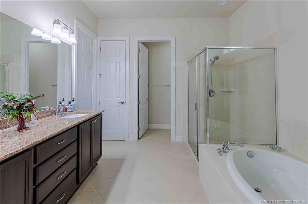1092 Southwest Scrub Oak Avenue Palm City, FL 34990 - Photo 13 of 45 a bathroom with a granite countertop sink tub shower and a mirror
