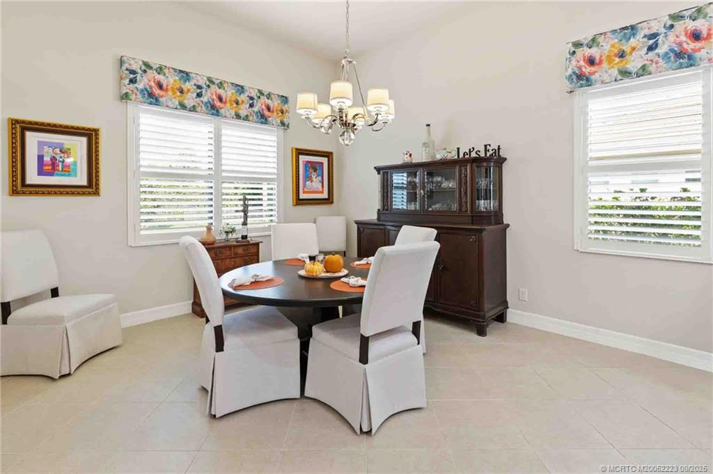 1092 Southwest Scrub Oak Avenue Palm City, FL 34990 - Photo 17 of 45 a view of a dining room with furniture and chandelier