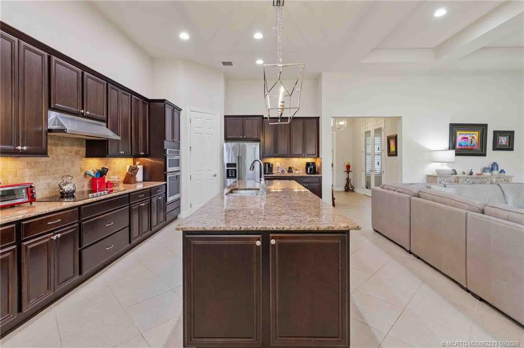 1092 Southwest Scrub Oak Avenue Palm City, FL 34990 - Photo 19 of 45 a kitchen with kitchen island granite countertop a sink and cabinets