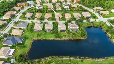 a front view of a multi story residential apartment building with yard and sign board