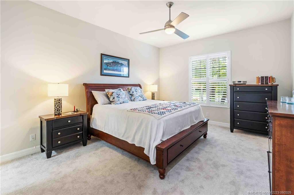 1092 Southwest Scrub Oak Avenue Palm City, FL 34990 - Photo 26 of 45 a bedroom with a bed and a chandelier