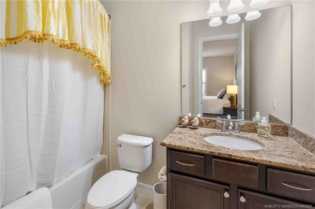 1092 Southwest Scrub Oak Avenue Palm City, FL 34990 - Photo 27 of 45 a bathroom with a granite countertop sink toilet and mirror
