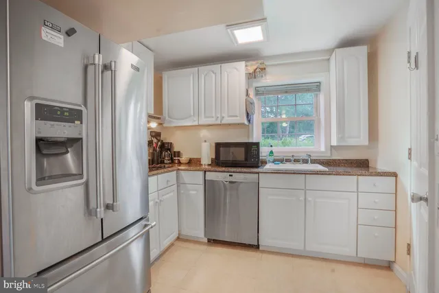 a kitchen with a refrigerator sink and cabinets