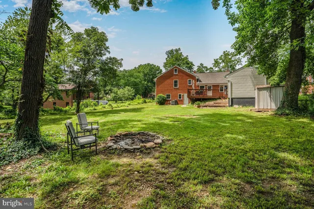 a view of a house with a big yard and large trees