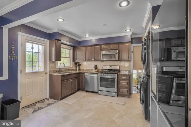 a kitchen with granite countertop a refrigerator stove and oven