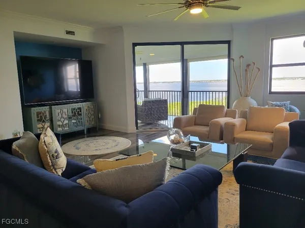 a living room with furniture a large window and a flat screen tv