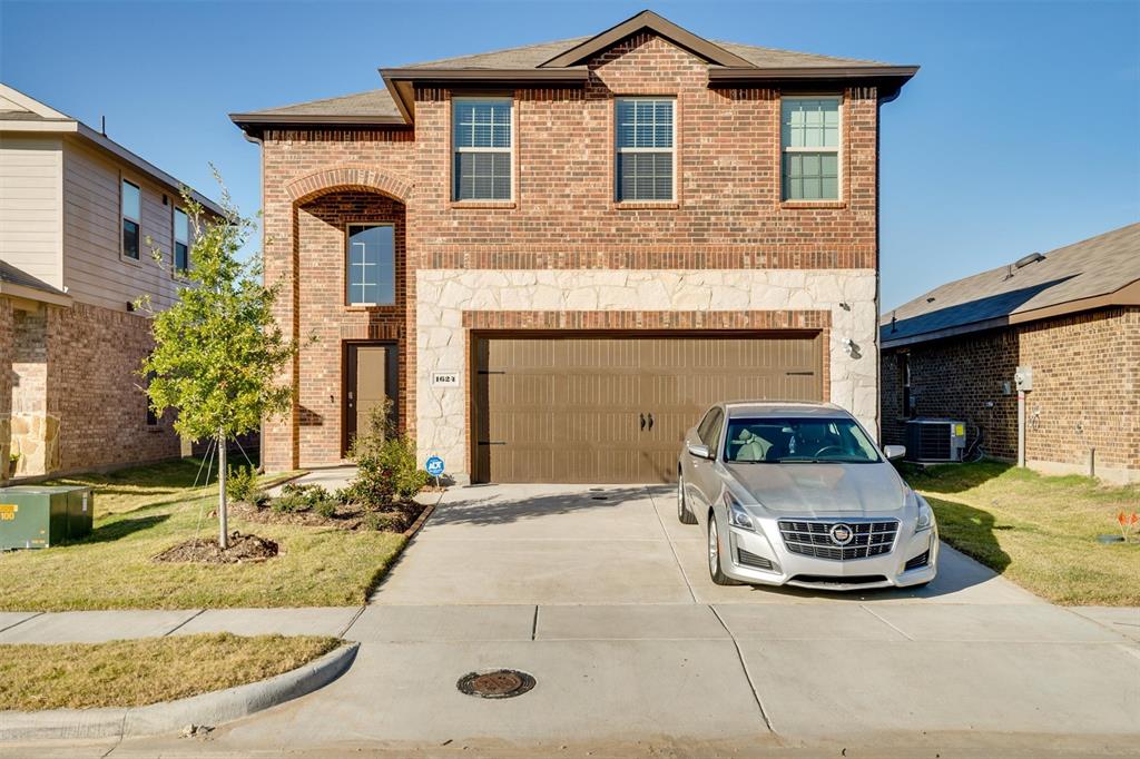 a car parked in front of a brick house