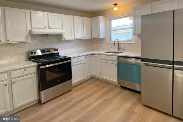 a kitchen with granite countertop white cabinets and white appliances