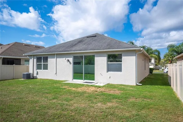 a view of a house with a yard and fence