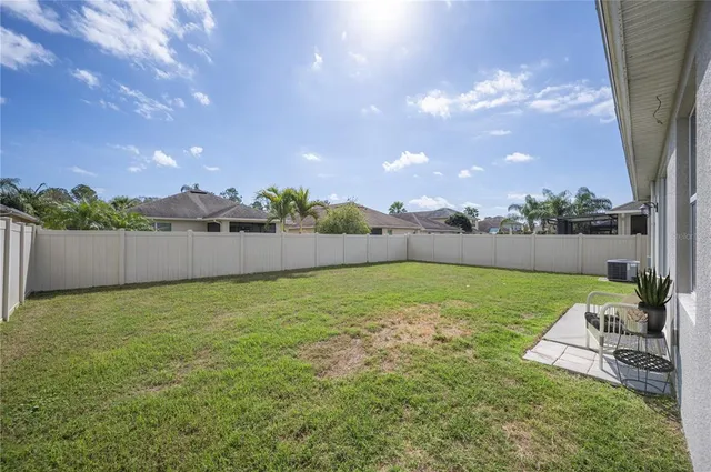 a backyard of a house with a yard and outdoor seating