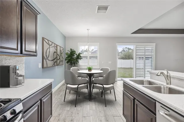 a kitchen with a table chairs sink and cabinets