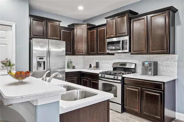 a kitchen with stainless steel appliances granite countertop a sink stove and refrigerator