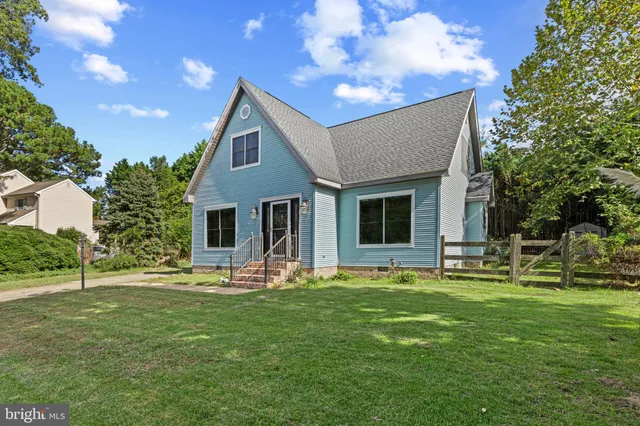 a front view of house with a garden and trees