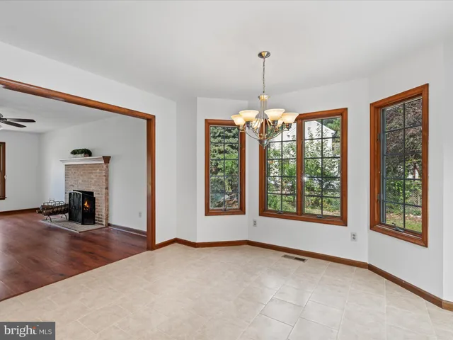 a view of an empty room with window and chandelier