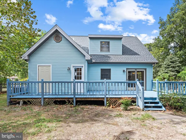 a view of house with wooden fence and a roof