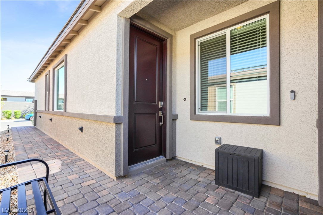9398 Noble Fir Rdg Court Las Vegas, NV 89143 - Photo 21 of 36 A welcoming entry features a rich brown door, contrasting against the light stucco, and a neatly paved pathway.