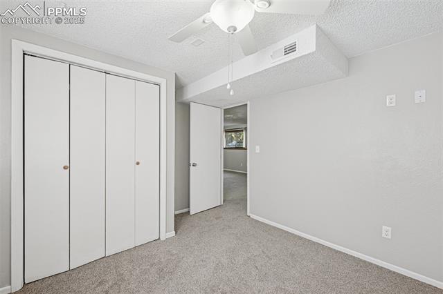 7233 River Bend Road Colorado Springs, CO 80911 - Photo 32 of 44 second lower level bedroom, closet built ins, garden level window with good light filtering in, new paint.