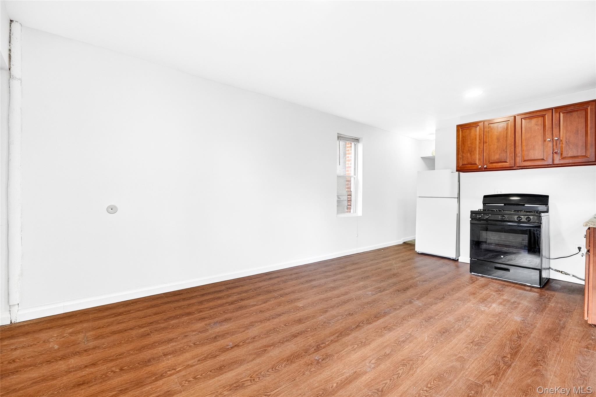 989 Sacket Avenue Bronx, NY 10462 - Photo 21 of 29 a view of an empty room with a window and wooden floor