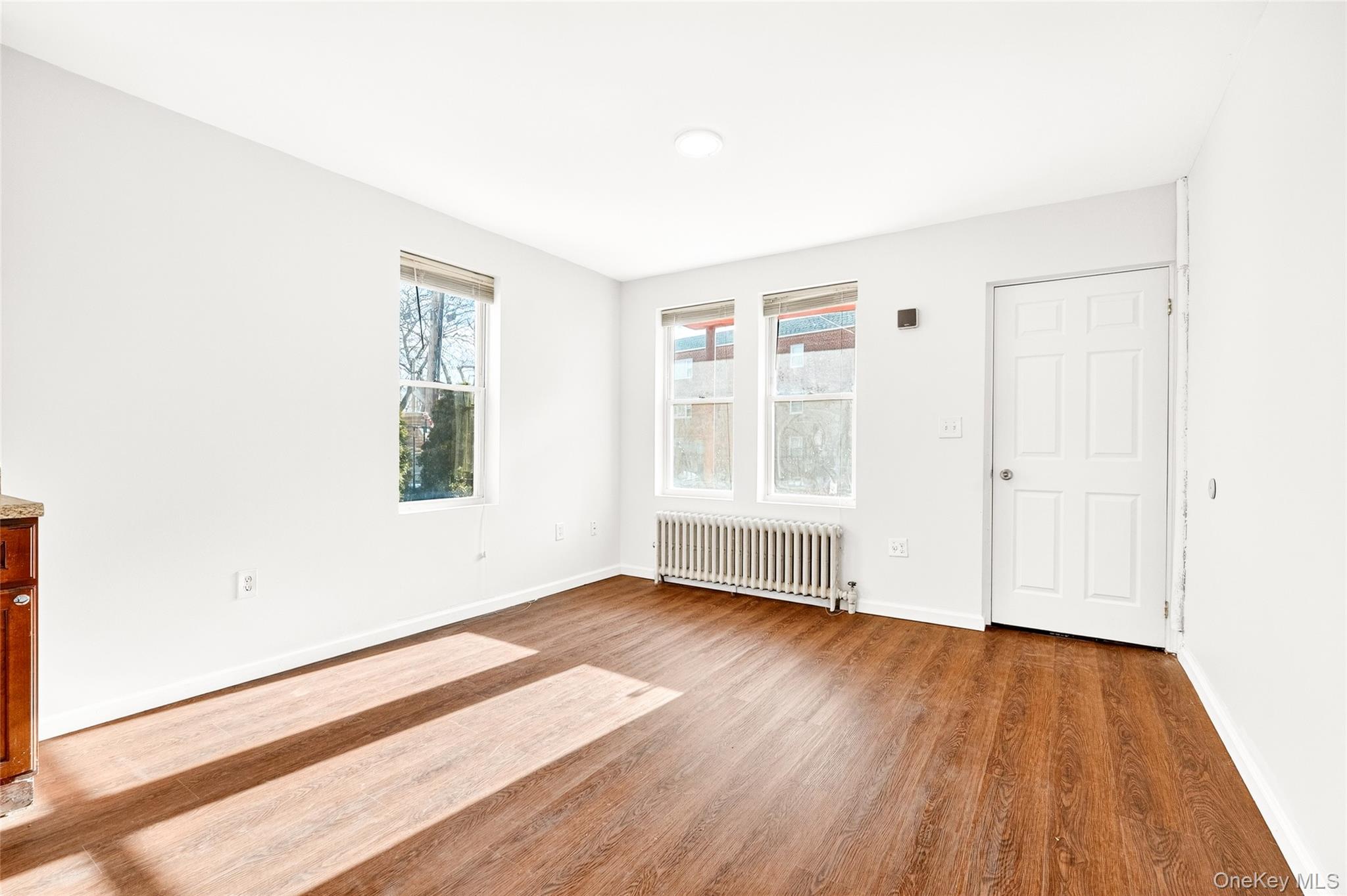 989 Sacket Avenue Bronx, NY 10462 - Photo 22 of 29 an empty room with wooden floor and windows