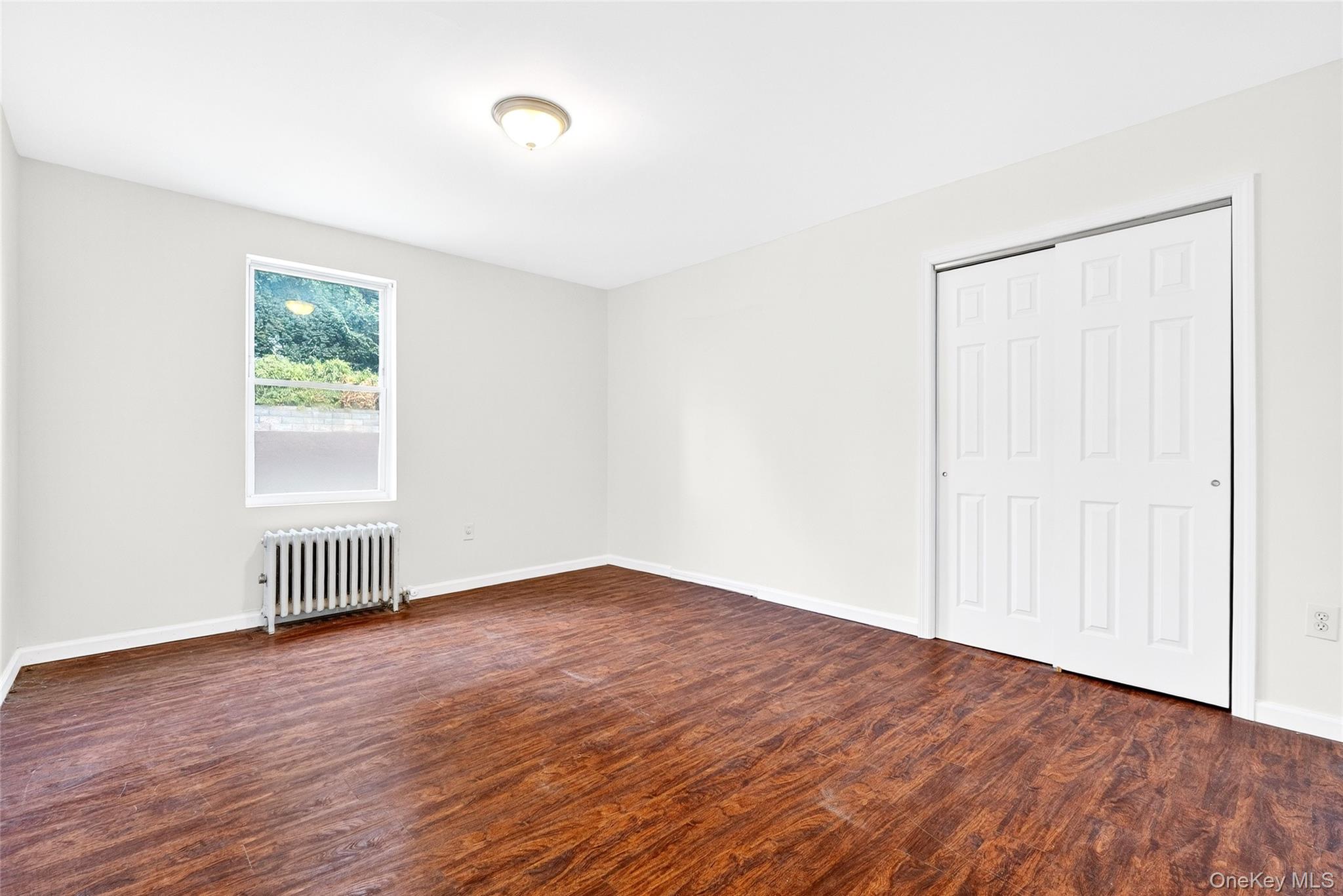 989 Sacket Avenue Bronx, NY 10462 - Photo 27 of 29 an empty room with wooden floor and windows