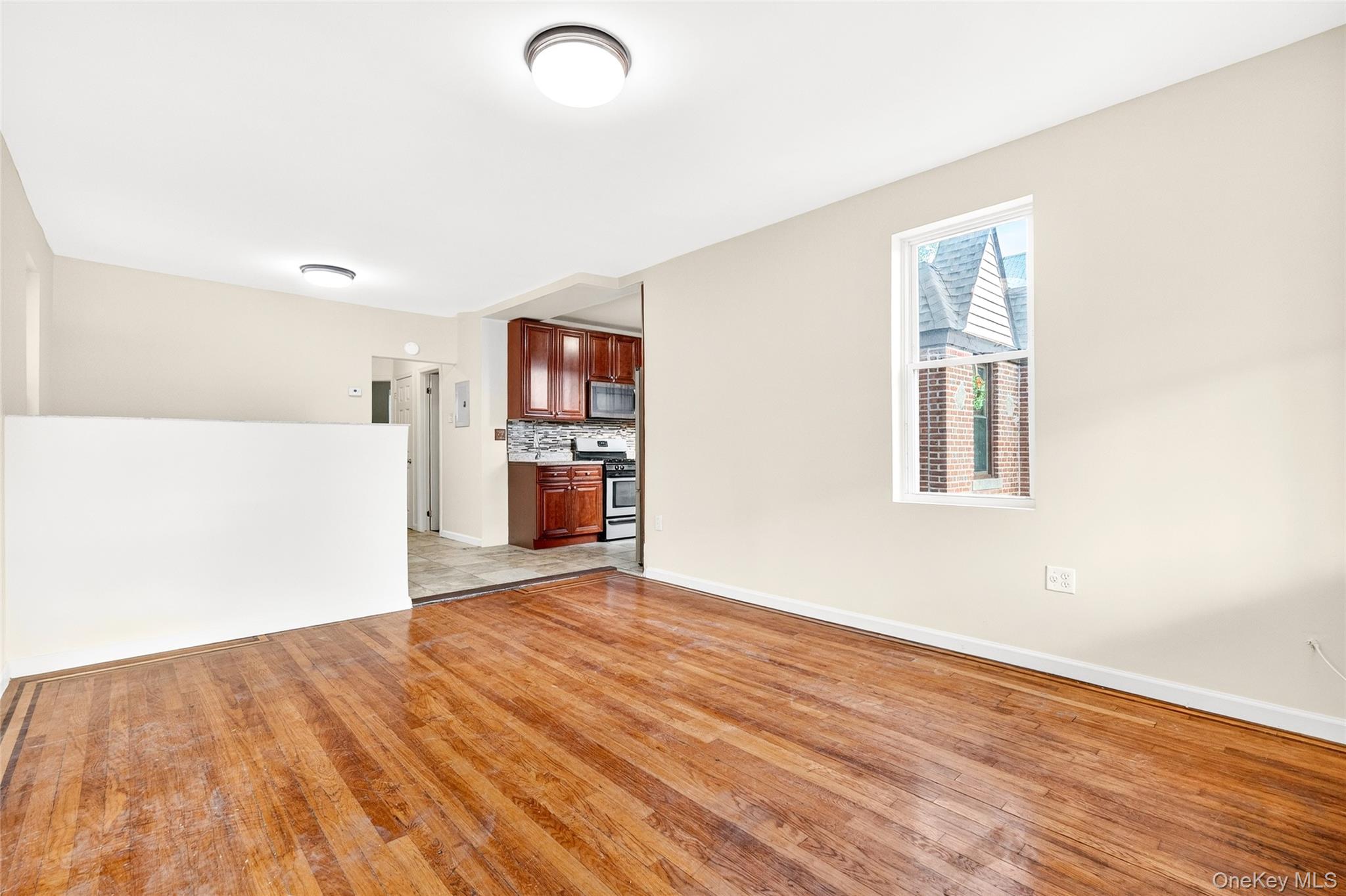 989 Sacket Avenue Bronx, NY 10462 - Photo 4 of 29 a view of empty room with wooden floor and kitchen view