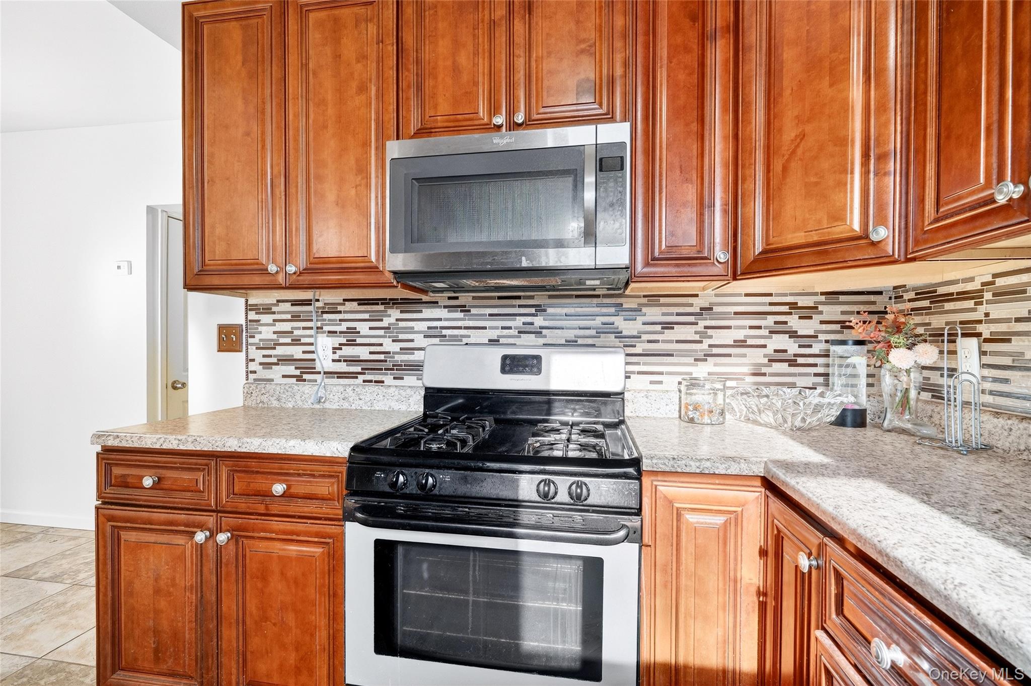 989 Sacket Avenue Bronx, NY 10462 - Photo 9 of 29 a kitchen with granite countertop a stove top oven cabinetry a sink and a window