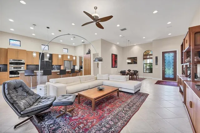 a living room with lots of furniture and stainless steel appliances
