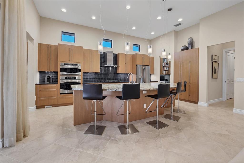 14519 Leopard Creek Place Lakewood Ranch, FL 34202 - Photo 15 of 56 a living room with lots of furniture and stainless steel appliances