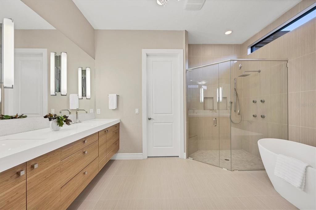 14519 Leopard Creek Place Lakewood Ranch, FL 34202 - Photo 24 of 56 a spacious bathroom with a granite countertop sink a toilet a mirror and shower