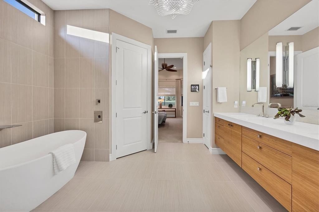 14519 Leopard Creek Place Lakewood Ranch, FL 34202 - Photo 26 of 56 a spacious bathroom with a double vanity sink a large mirror and a bathtub