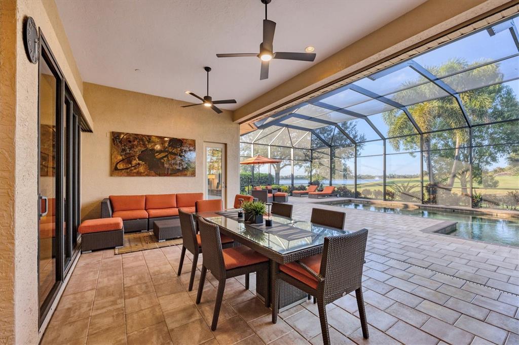 14519 Leopard Creek Place Lakewood Ranch, FL 34202 - Photo 36 of 56 a dining room with furniture a chandelier and window